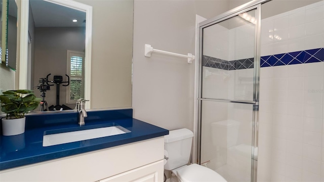 bathroom featuring vanity, toilet, and a shower with door