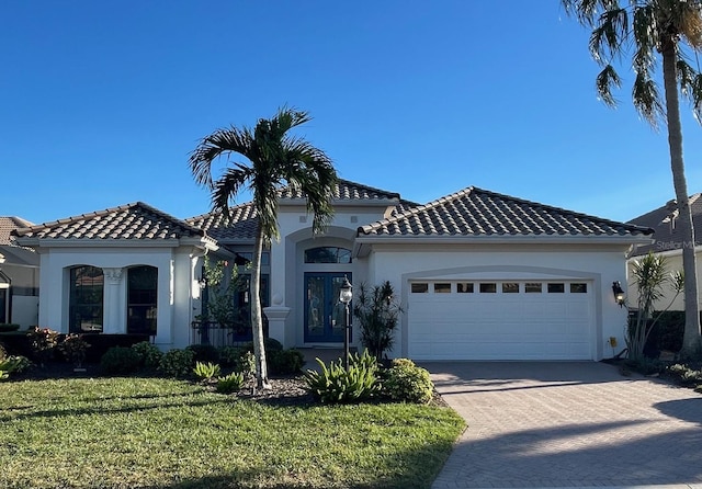 mediterranean / spanish-style house featuring a front lawn and a garage