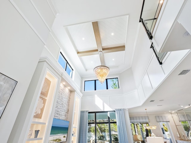 room details featuring a chandelier, beamed ceiling, crown molding, and coffered ceiling