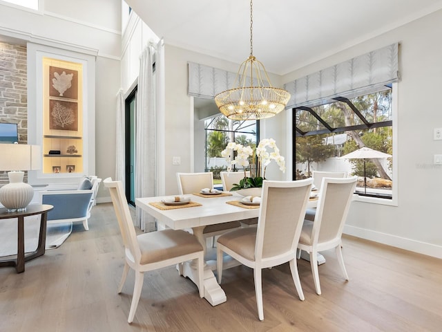 dining room featuring plenty of natural light, light hardwood / wood-style flooring, and an inviting chandelier