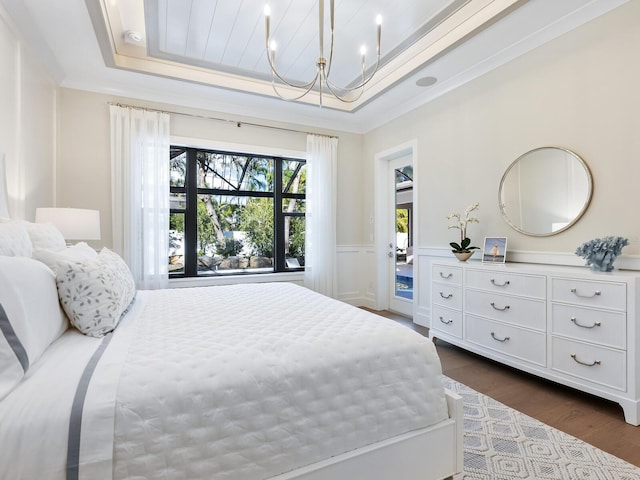 bedroom with a tray ceiling, crown molding, and dark wood-type flooring