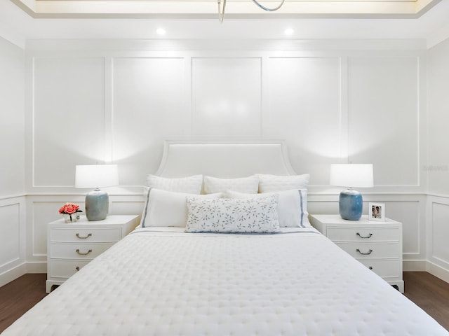 bedroom with dark hardwood / wood-style flooring and ornamental molding