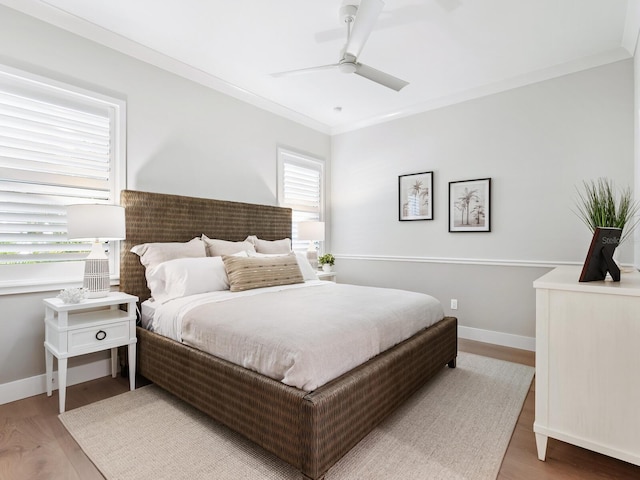 bedroom with light hardwood / wood-style floors, ceiling fan, and ornamental molding