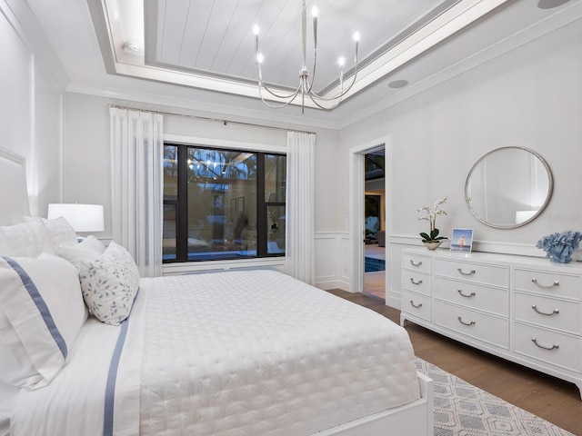 bedroom with dark hardwood / wood-style floors, ornamental molding, and a tray ceiling