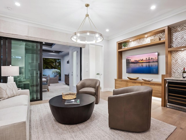 living room featuring crown molding, hardwood / wood-style floors, beverage cooler, and an inviting chandelier