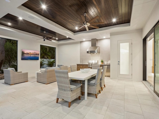 dining area featuring ceiling fan, a raised ceiling, wood ceiling, and sink