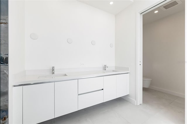 bathroom featuring vanity, tile patterned floors, and toilet