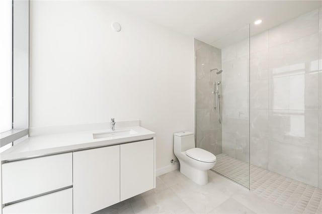 bathroom featuring tiled shower, vanity, and toilet