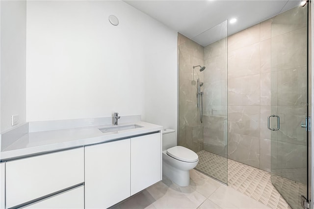 bathroom featuring walk in shower, vanity, toilet, and tile patterned flooring