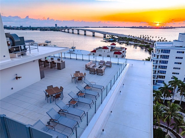 aerial view at dusk featuring a water view