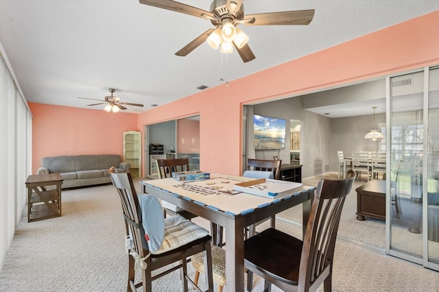 dining area featuring ceiling fan and light colored carpet