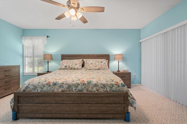 carpeted bedroom featuring a textured ceiling and ceiling fan