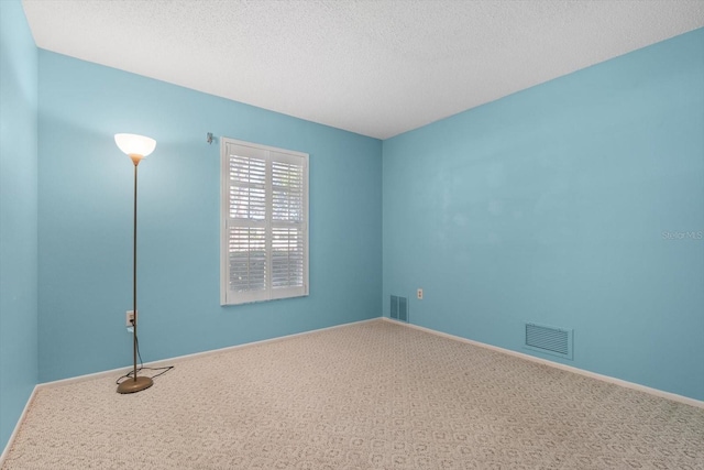 carpeted spare room featuring a textured ceiling