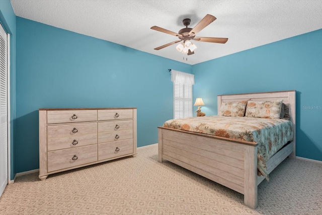 carpeted bedroom featuring a textured ceiling, ceiling fan, and a closet