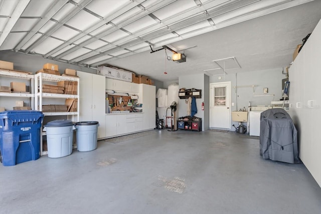 garage with a garage door opener, sink, and washer and clothes dryer