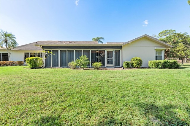 back of house with a sunroom and a lawn