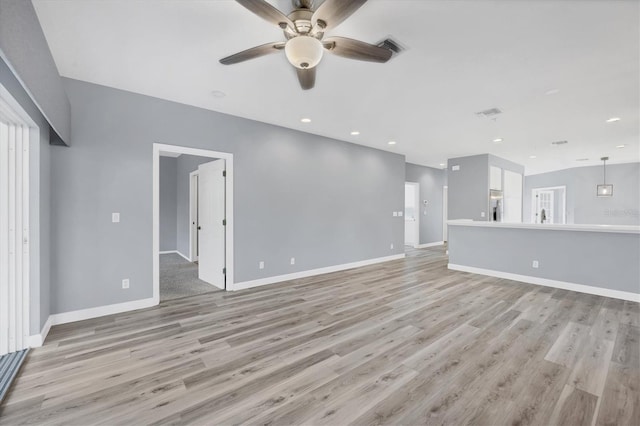 unfurnished living room with light hardwood / wood-style floors, ceiling fan, and sink