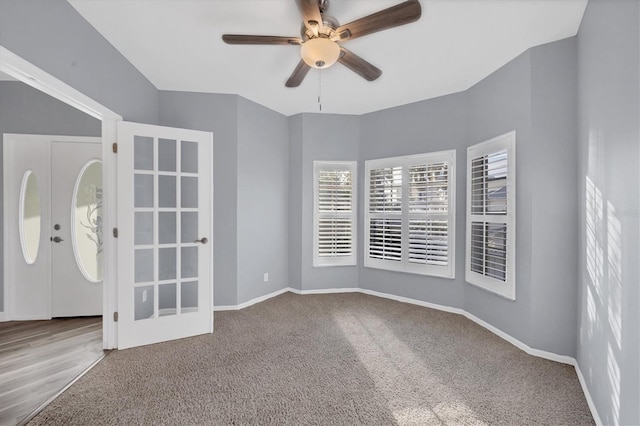 carpeted empty room featuring ceiling fan and french doors