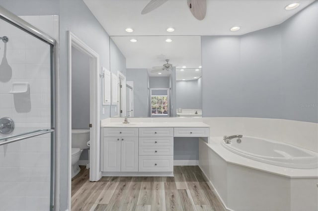 full bathroom with ceiling fan, separate shower and tub, wood-type flooring, toilet, and vanity