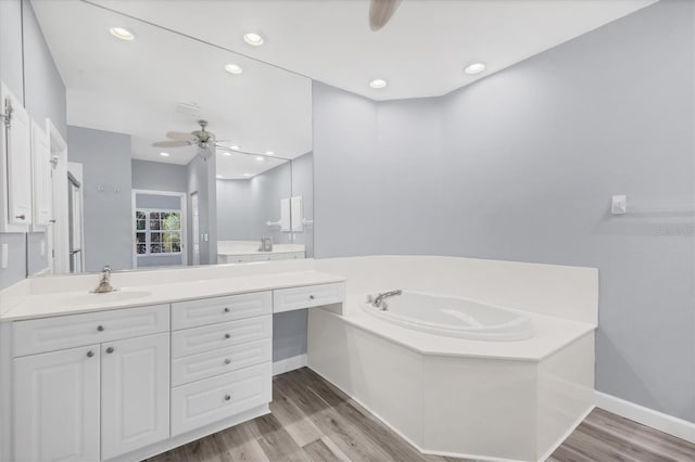 bathroom with ceiling fan, a washtub, vanity, and hardwood / wood-style floors