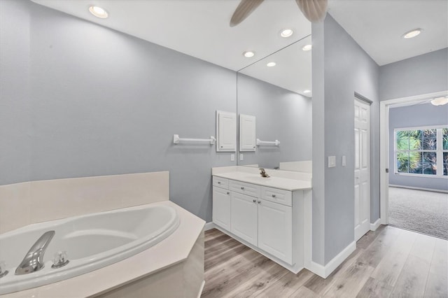 bathroom featuring hardwood / wood-style floors, vanity, and a washtub