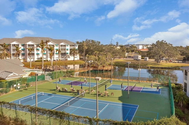 view of tennis court with a water view