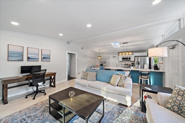 living room featuring light tile patterned flooring and vaulted ceiling with skylight