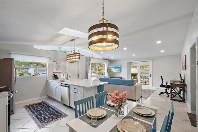 dining area featuring sink, a skylight, an inviting chandelier, and light tile patterned floors