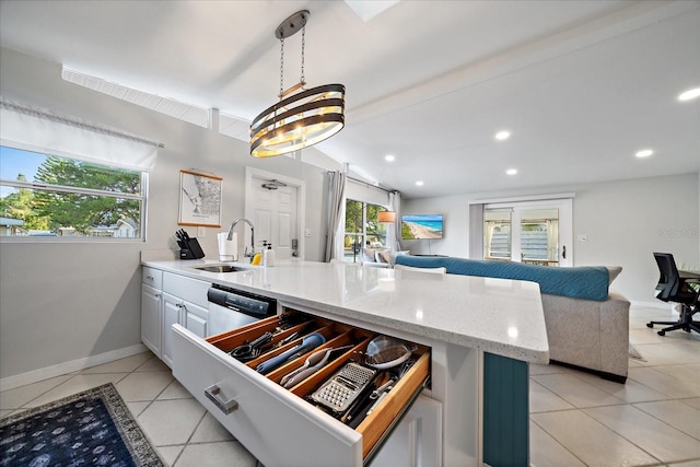 kitchen with white cabinets, dishwasher, hanging light fixtures, sink, and light tile patterned floors