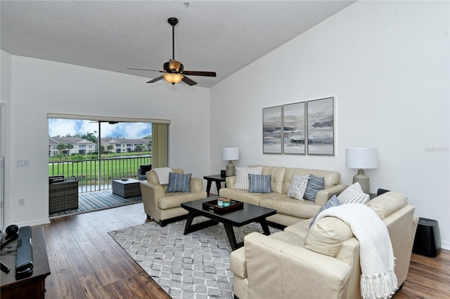 living room with a textured ceiling, lofted ceiling, hardwood / wood-style flooring, and ceiling fan