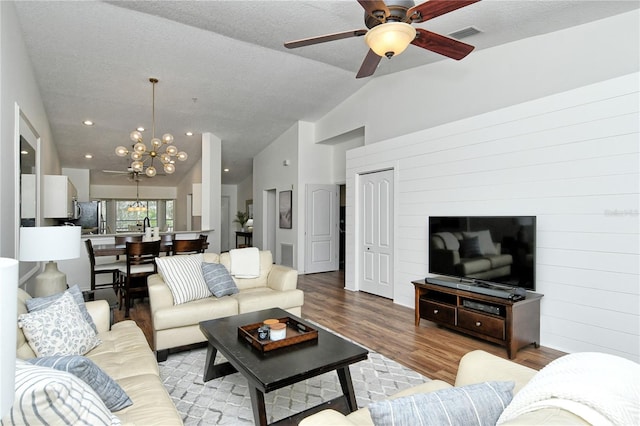 living room with light wood-type flooring, ceiling fan with notable chandelier, lofted ceiling, and a textured ceiling