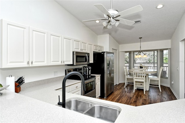 kitchen featuring appliances with stainless steel finishes, decorative light fixtures, dark hardwood / wood-style floors, white cabinets, and lofted ceiling