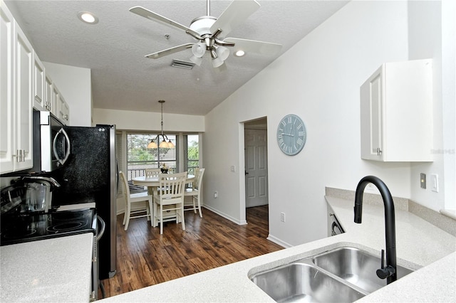 kitchen with dark wood-type flooring, white cabinetry, sink, and vaulted ceiling