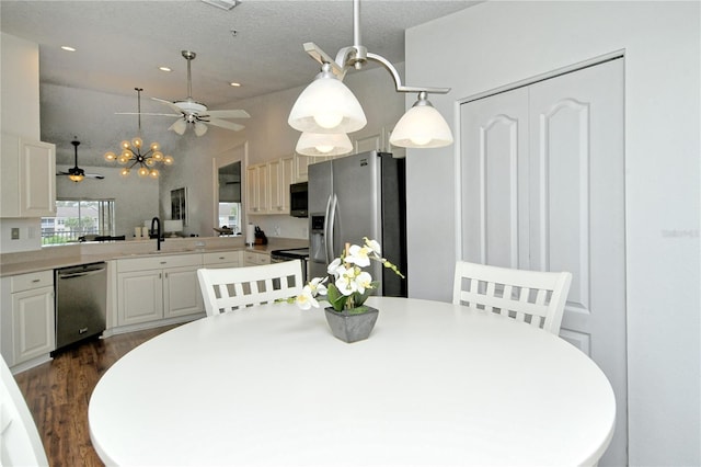 dining room with a textured ceiling, dark wood-type flooring, sink, and ceiling fan