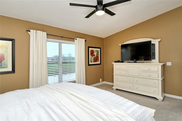 bedroom with a textured ceiling, light colored carpet, ceiling fan, and vaulted ceiling