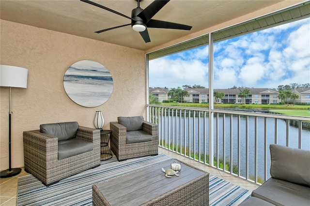 sunroom with a water view and ceiling fan