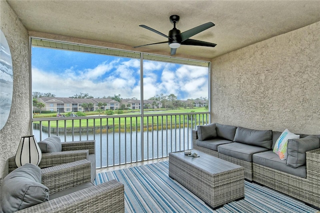 sunroom featuring ceiling fan, plenty of natural light, and a water view