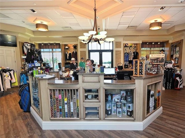 bar featuring dark hardwood / wood-style floors, decorative light fixtures, and an inviting chandelier