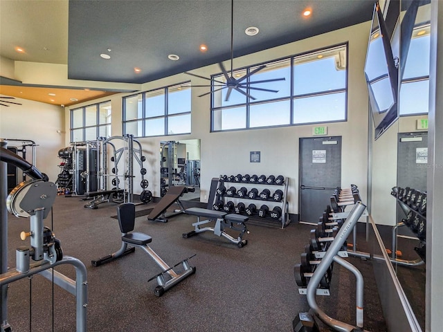 workout area with a textured ceiling, a towering ceiling, and ceiling fan