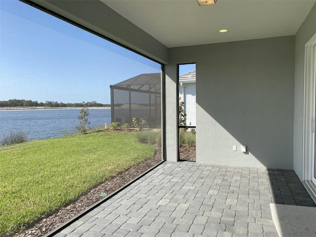 view of patio / terrace featuring a water view and a lanai