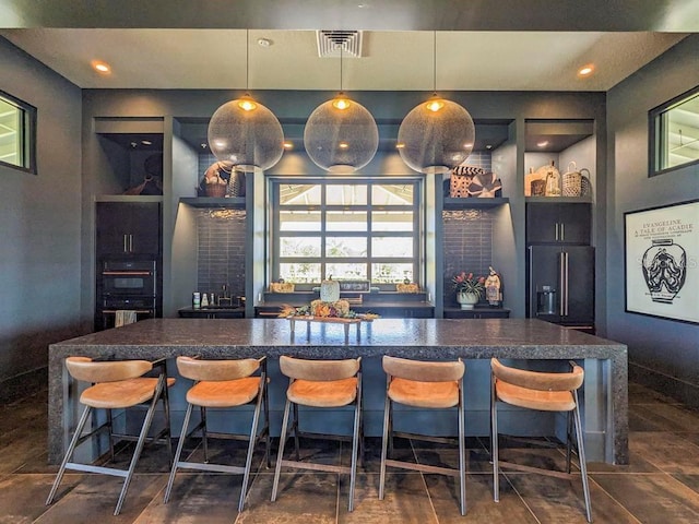 bar with pendant lighting, black double oven, and high quality fridge