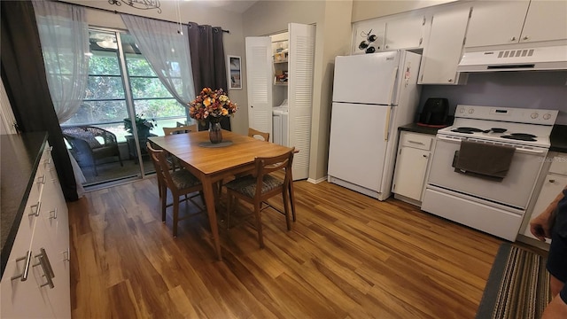 kitchen with vaulted ceiling, white cabinets, white appliances, and hardwood / wood-style flooring