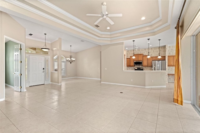 unfurnished living room featuring ceiling fan with notable chandelier, a raised ceiling, light tile patterned floors, and crown molding