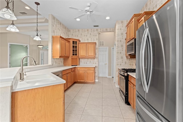 kitchen featuring stainless steel appliances, sink, ornamental molding, ceiling fan, and decorative light fixtures