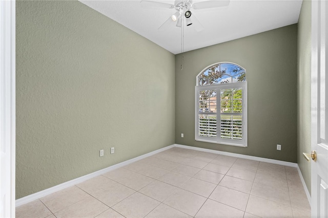 tiled empty room featuring ceiling fan