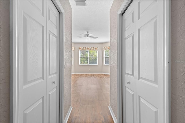 hall featuring hardwood / wood-style floors and a textured ceiling