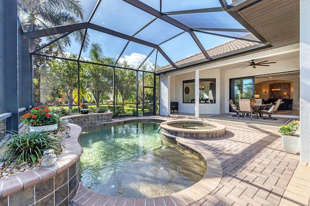 view of pool featuring glass enclosure, ceiling fan, a patio, and an in ground hot tub