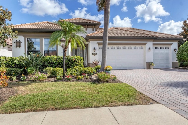 mediterranean / spanish home featuring a garage and a front yard