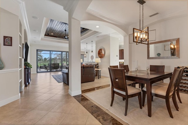 dining area with ceiling fan with notable chandelier, light tile patterned floors, crown molding, and a tray ceiling