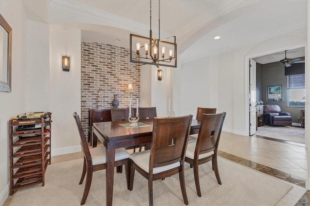 tiled dining space with ceiling fan with notable chandelier and ornamental molding